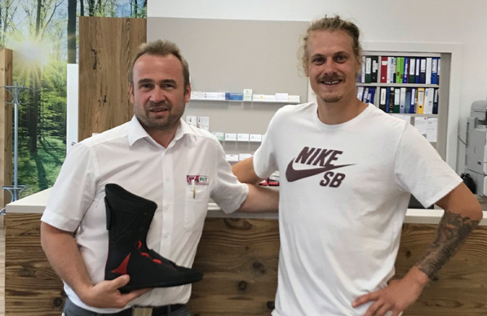 Stefan Pilz mit Skischuh in der Hand neben Manuel Kellner