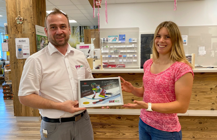 Stefan Pilz mit Katharina Liensberger bei Übergabe von signiertem Bild